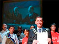Mayor of Newham and children on stage with projection screen in background